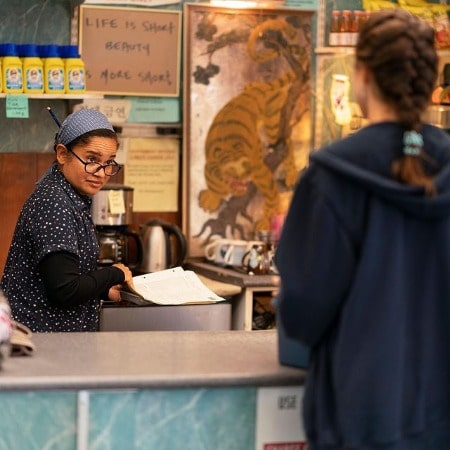 Picture of Tracy Ferrin in a black dress in the scene of a series
